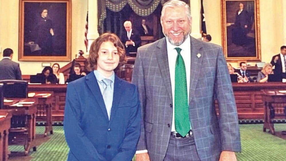 A man and a boy stand together in front of a room, showcasing a moment of connection and companionship.